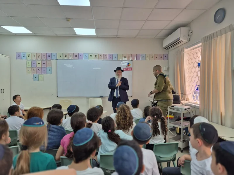 תלמידים יושבים בכיתה ומקשיבים למפגש, על הקיר אותיות האלף־בית